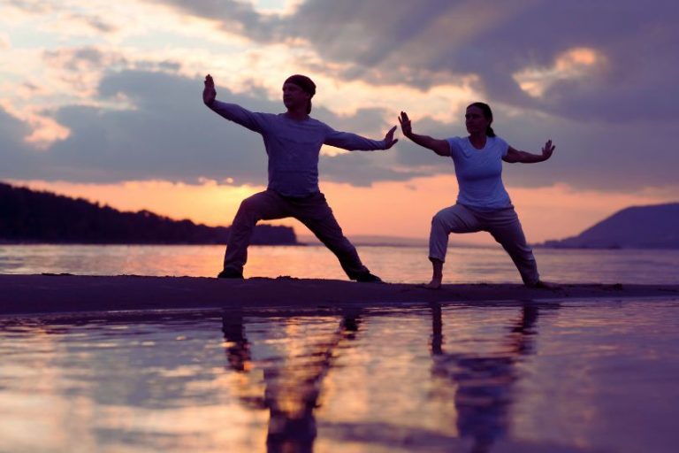 Deux personnes sur une plage qui pratiquent le Tai CHi