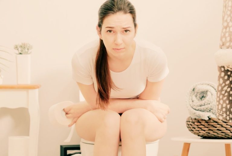 Une femme constipé sur ses toilettes