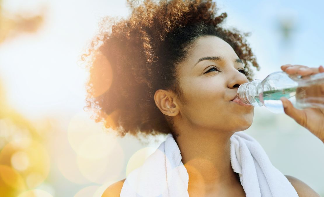 Une femme qui s'hydrate pendant une séance de sport